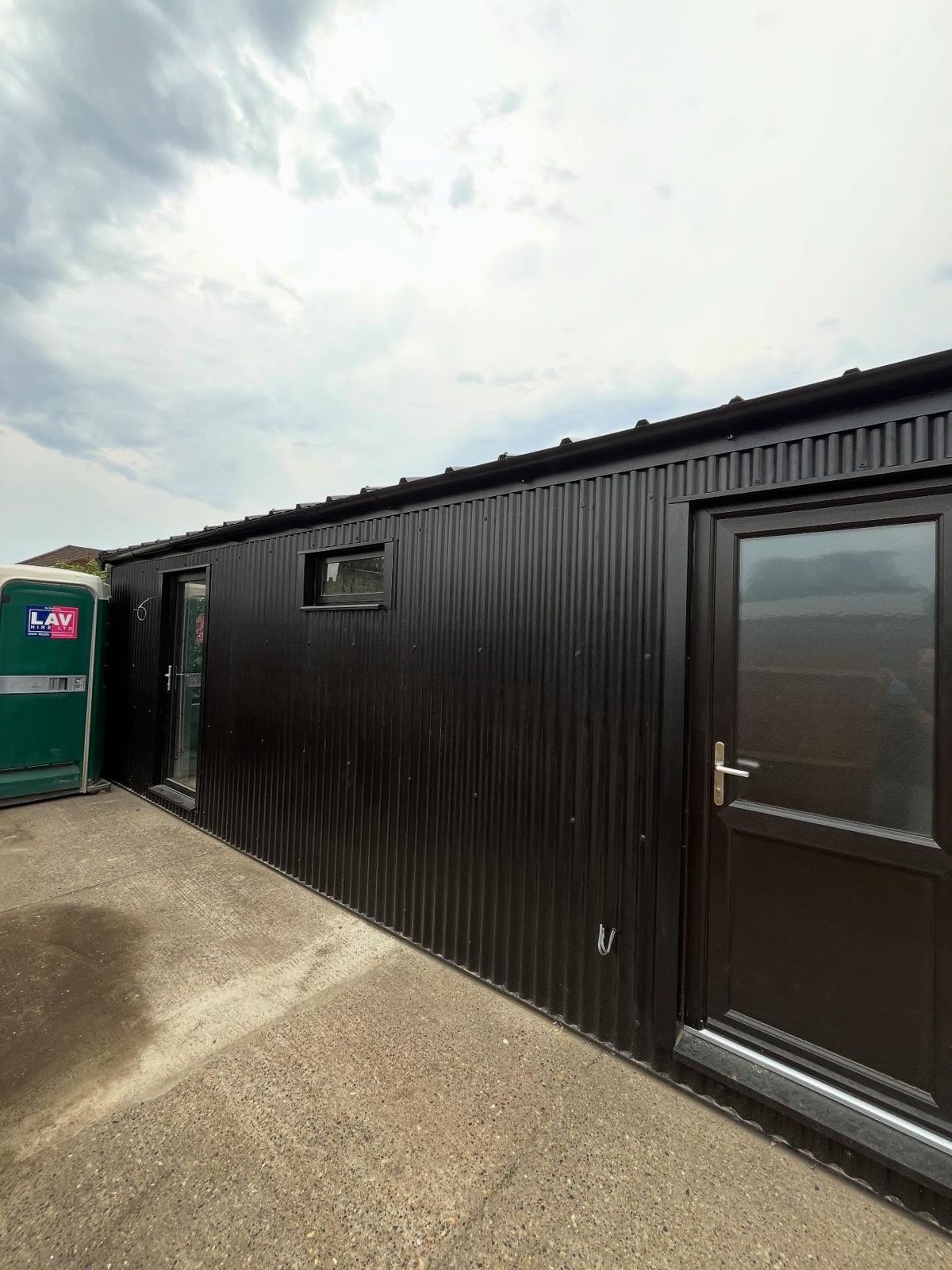 Finished garage conversion with black cladding, glazed door and windows