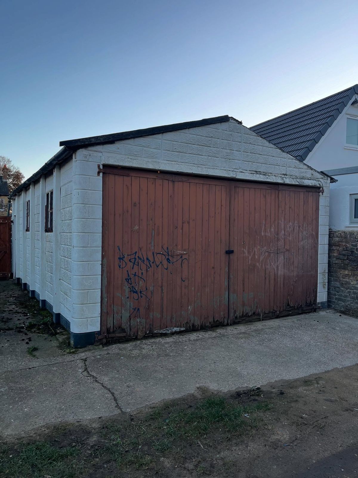Old garage with brown up-and-over doors before work started