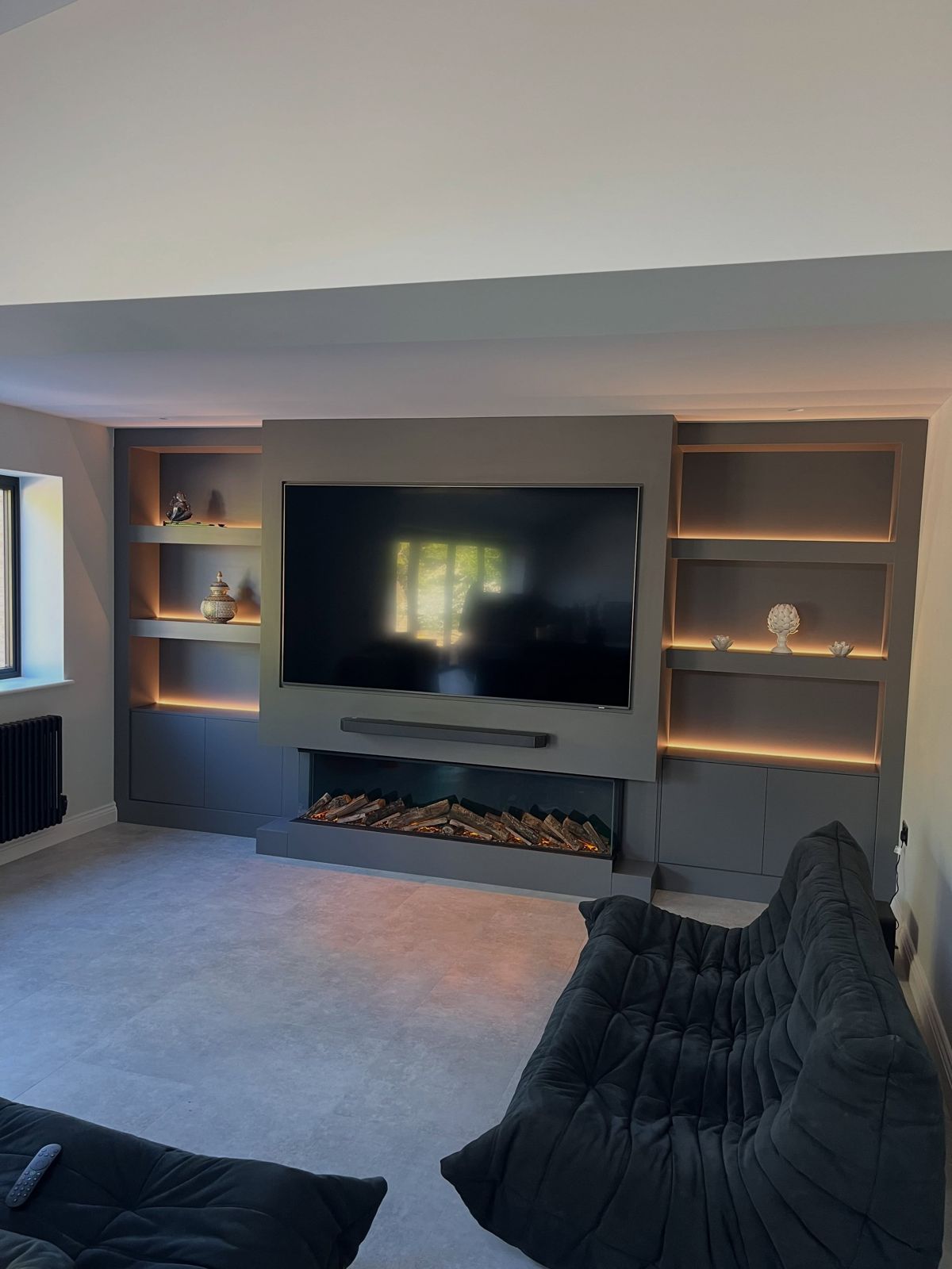 Bespoke media wall with inset TV, fire and lit shelving in the Gillingham extension